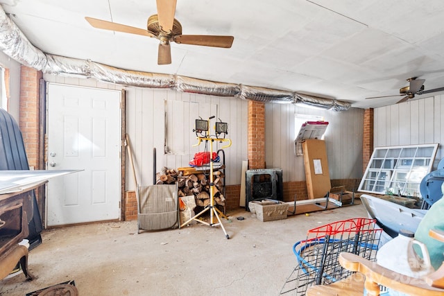 basement featuring a wood stove and ceiling fan