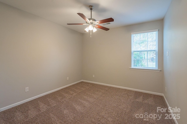 carpeted empty room featuring visible vents, ceiling fan, and baseboards