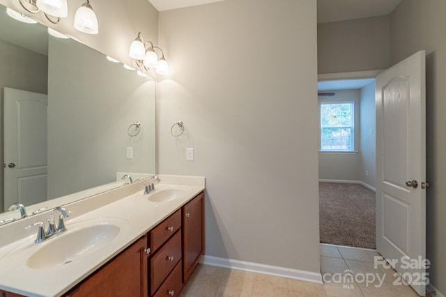 full bathroom featuring double vanity, baseboards, a sink, and tile patterned floors