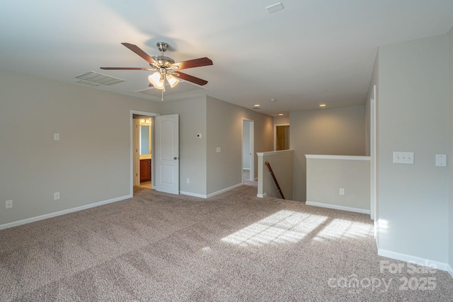 carpeted spare room with baseboards, visible vents, and ceiling fan