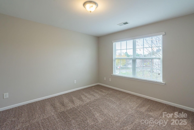 carpeted empty room featuring visible vents and baseboards