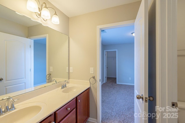 bathroom featuring double vanity, baseboards, and a sink