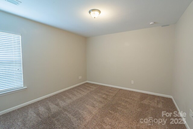 carpeted spare room with baseboards and visible vents