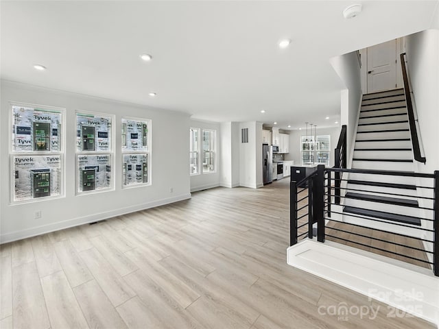 unfurnished living room with recessed lighting, stairway, light wood-style flooring, and baseboards