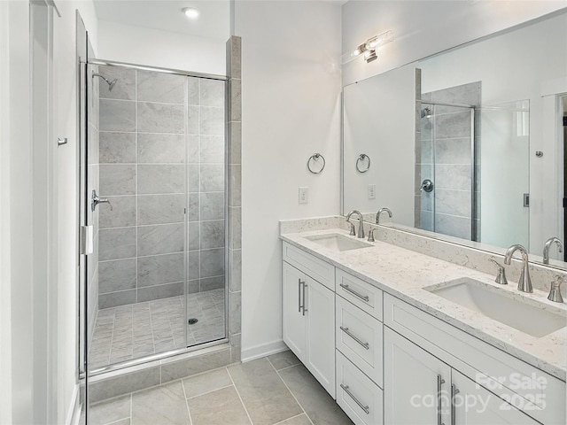 full bathroom with double vanity, a sink, and a shower stall