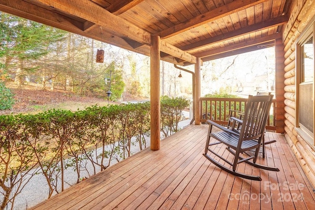 wooden deck with a water view and covered porch