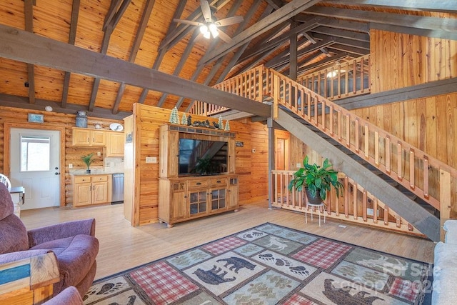 living room featuring beamed ceiling, light hardwood / wood-style flooring, wooden ceiling, and wood walls