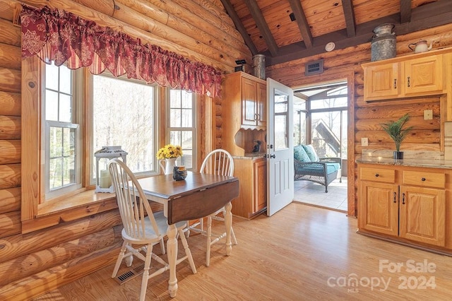 dining room featuring lofted ceiling with beams, light hardwood / wood-style flooring, rustic walls, and wooden ceiling