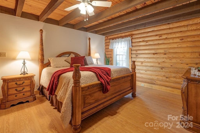 bedroom featuring ceiling fan, log walls, beamed ceiling, light hardwood / wood-style floors, and wood ceiling