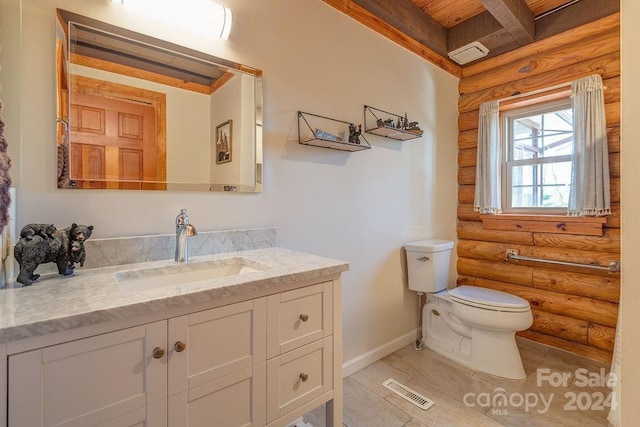 bathroom with vanity, tile patterned flooring, log walls, and toilet