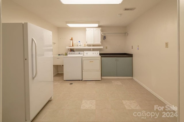 washroom featuring washer and dryer and cabinets