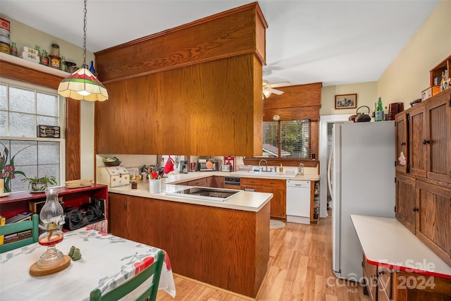 kitchen with kitchen peninsula, refrigerator, dishwasher, light hardwood / wood-style floors, and hanging light fixtures