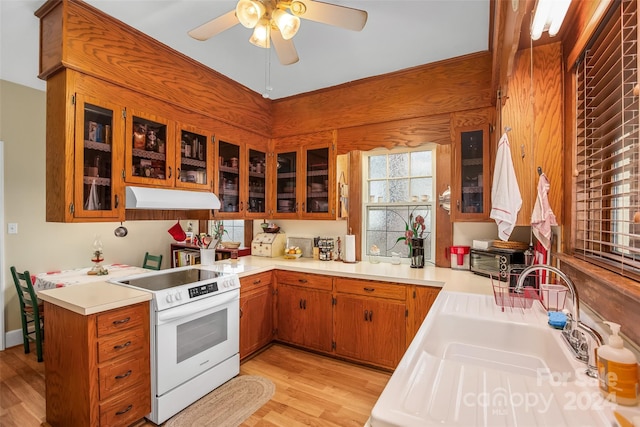 kitchen with ceiling fan, sink, white electric stove, kitchen peninsula, and light wood-type flooring