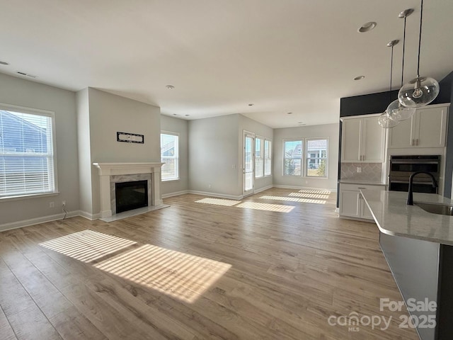 405 Northgate Blvd, Indian Trail, NC 28079 - unfurnished living room with a sink, a premium fireplace, light wood-type flooring, baseboards, and recessed lighting