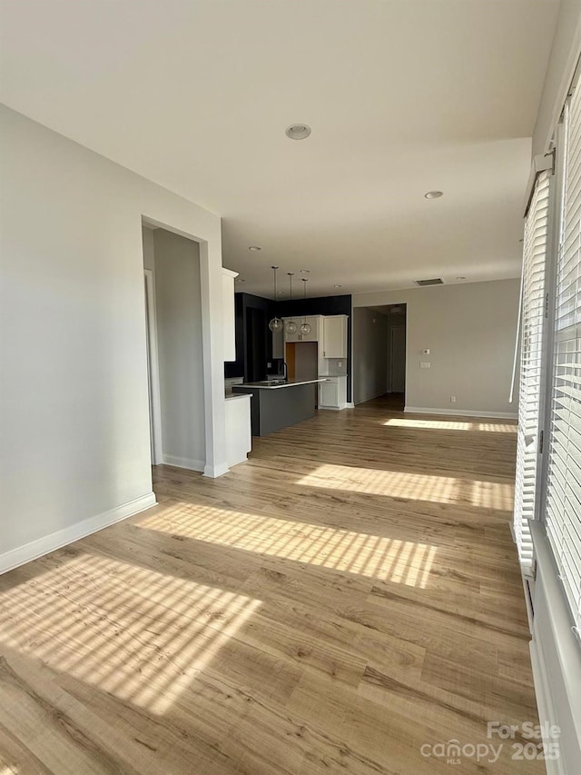 405 Northgate Blvd, Indian Trail, NC 28079 - unfurnished living room featuring baseboards and light wood-type flooring