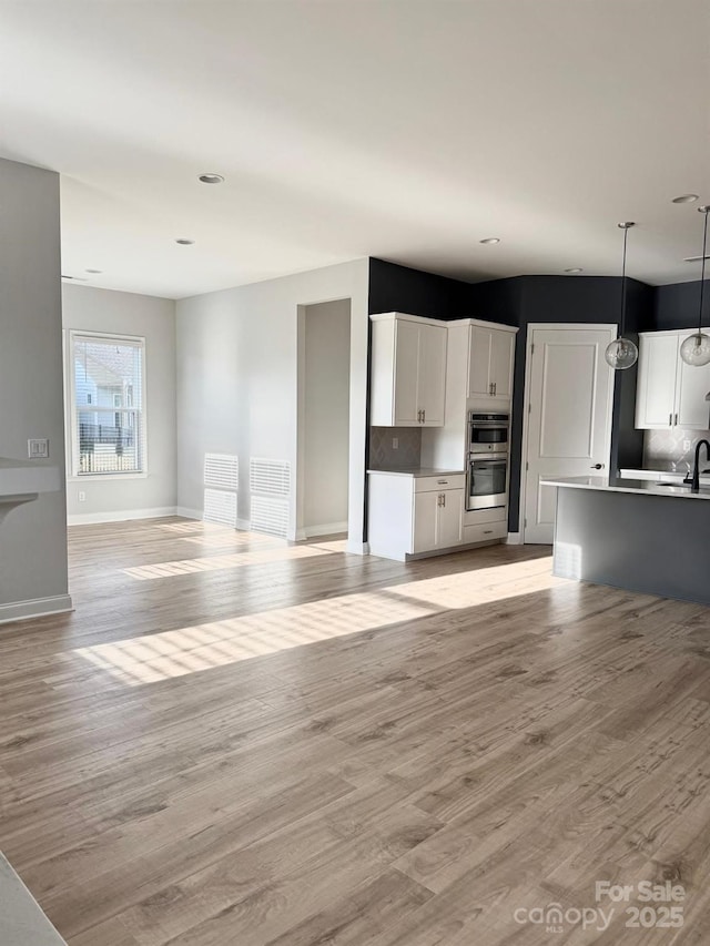 405 Northgate Blvd, Indian Trail, NC 28079 - unfurnished living room featuring light wood-style floors, a sink, baseboards, and recessed lighting