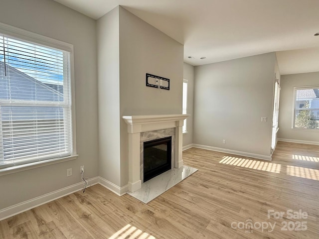 405 Northgate Blvd, Indian Trail, NC 28079 - unfurnished living room featuring baseboards, light wood-type flooring, and a high end fireplace