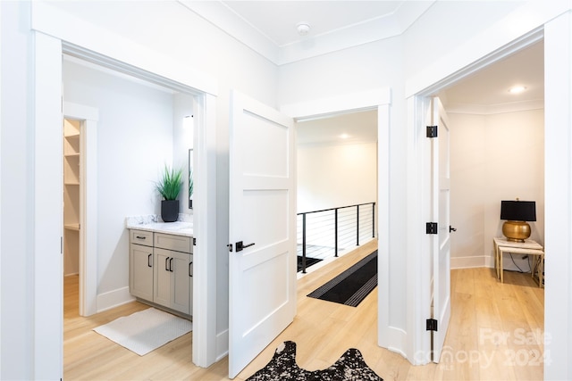 corridor featuring light hardwood / wood-style floors and ornamental molding