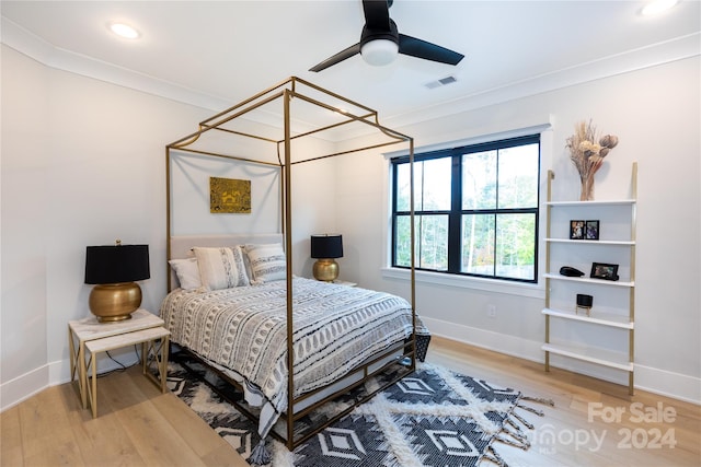 bedroom with ceiling fan, wood-type flooring, and ornamental molding