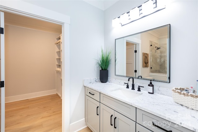 bathroom featuring vanity, wood-type flooring, and walk in shower