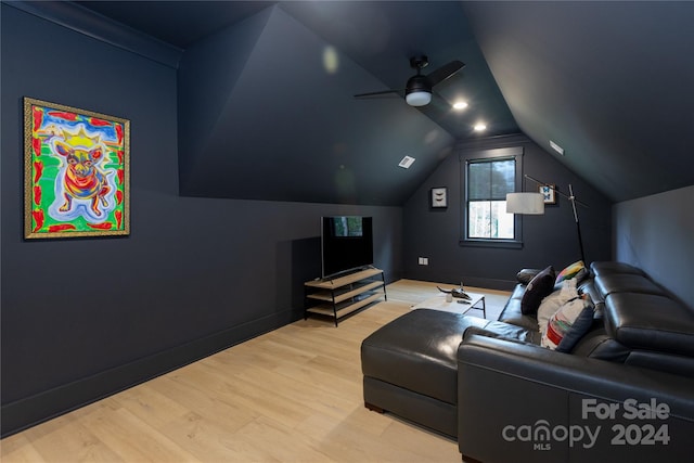 home theater with ceiling fan, light hardwood / wood-style floors, and vaulted ceiling