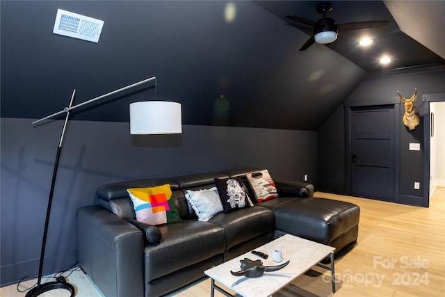 cinema room with ceiling fan, light hardwood / wood-style floors, and lofted ceiling