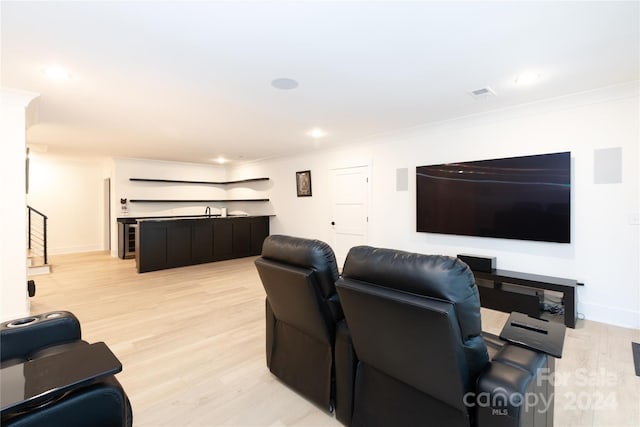 living room featuring light hardwood / wood-style flooring, crown molding, and sink