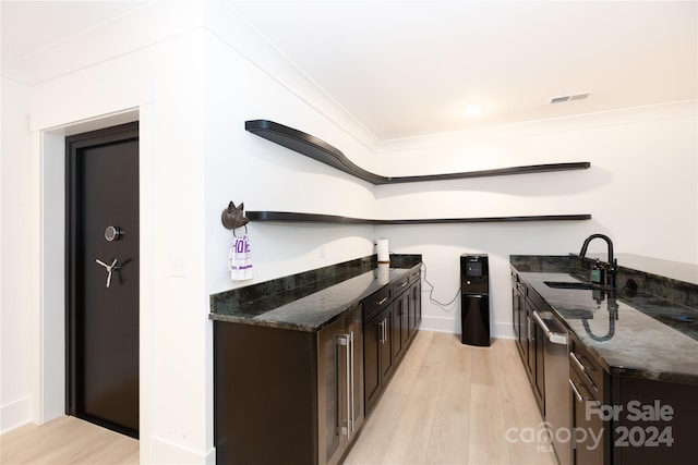 kitchen featuring dark brown cabinetry, sink, dark stone countertops, and light hardwood / wood-style floors