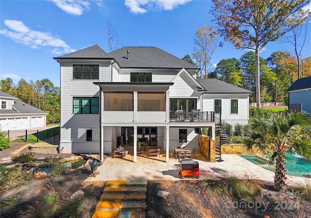 rear view of property featuring a sunroom, a jacuzzi, and a patio