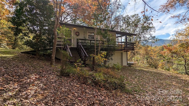 rear view of property featuring a deck with mountain view and a garage