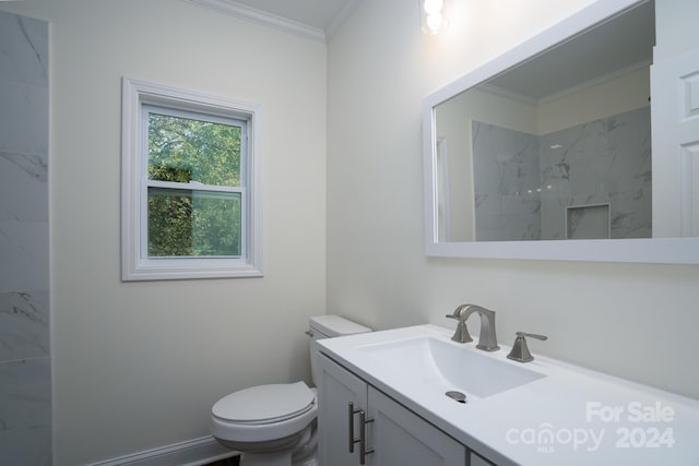 bathroom with vanity, toilet, crown molding, and a tile shower