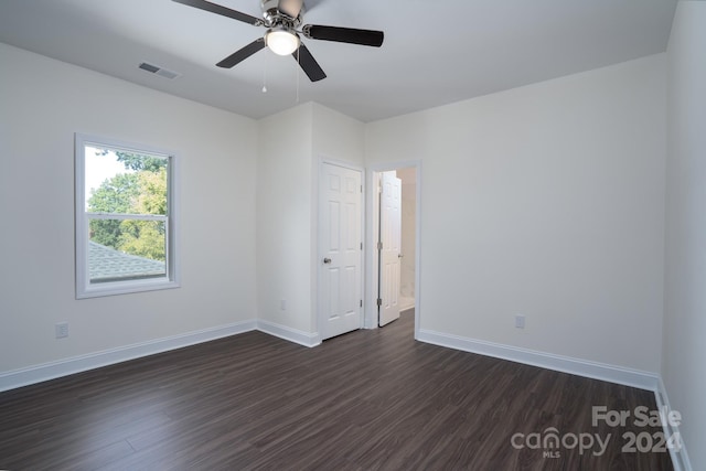 unfurnished room featuring ceiling fan and dark wood-type flooring