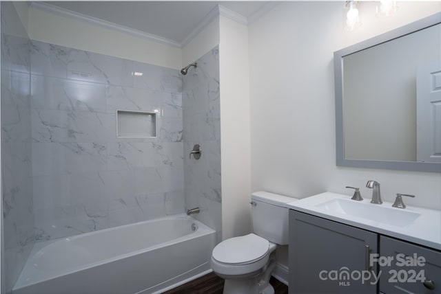 full bathroom with hardwood / wood-style floors, vanity, tiled shower / bath, toilet, and ornamental molding