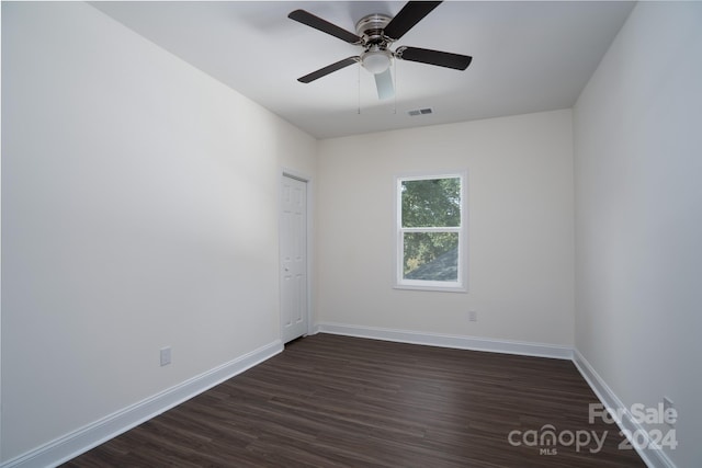 empty room with ceiling fan and dark hardwood / wood-style flooring