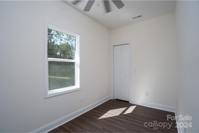 spare room with dark hardwood / wood-style floors and ceiling fan