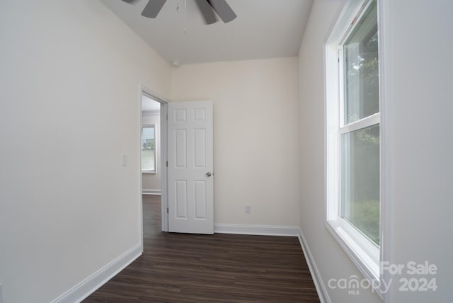 empty room with plenty of natural light, dark hardwood / wood-style floors, and ceiling fan