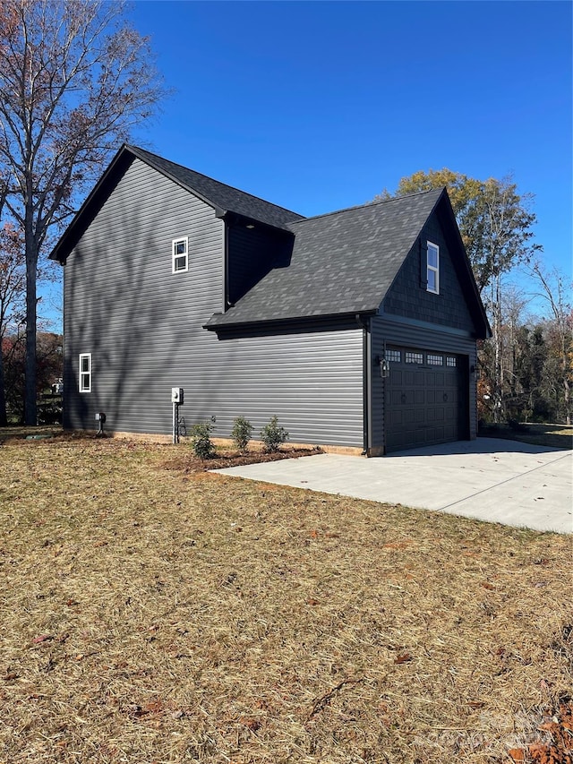 view of side of property featuring a garage and a yard