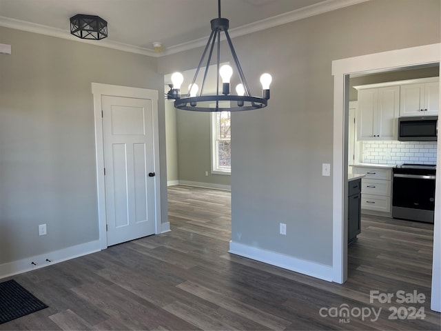 unfurnished dining area with dark hardwood / wood-style flooring, an inviting chandelier, and ornamental molding