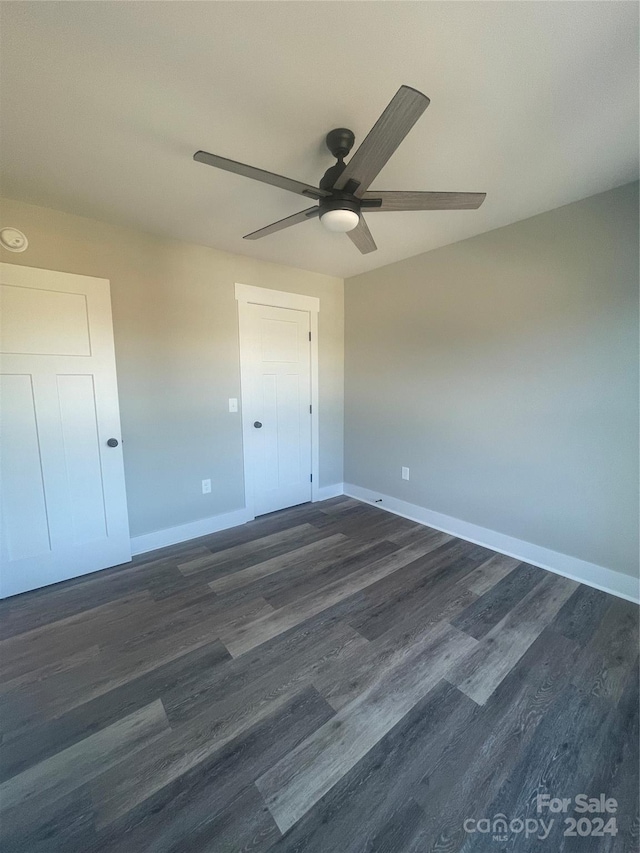 unfurnished bedroom featuring dark hardwood / wood-style floors and ceiling fan