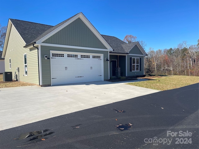 view of front of home featuring a garage and central air condition unit