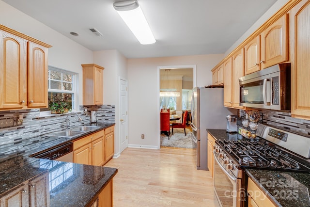 kitchen featuring light brown cabinets, appliances with stainless steel finishes, and a sink