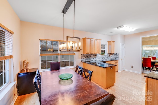 dining area featuring light wood-type flooring and baseboards