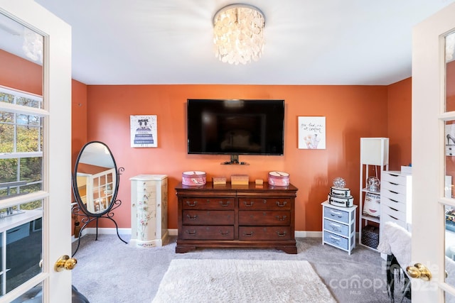 bedroom with light carpet, baseboards, and a notable chandelier