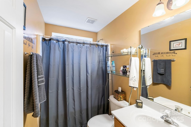 bathroom featuring toilet, vanity, visible vents, and a shower with curtain