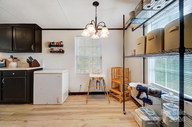 interior space with light hardwood / wood-style flooring, a notable chandelier, crown molding, decorative light fixtures, and fridge