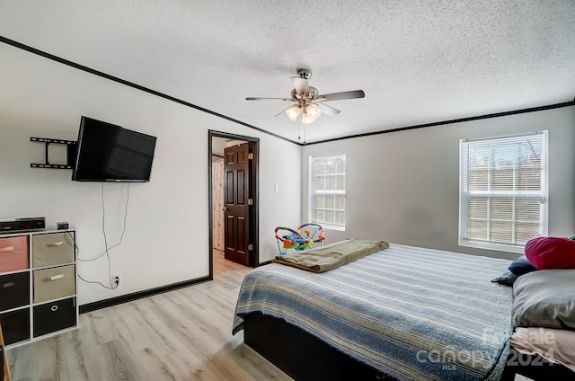 bedroom featuring ceiling fan, ornamental molding, a textured ceiling, and light wood-type flooring