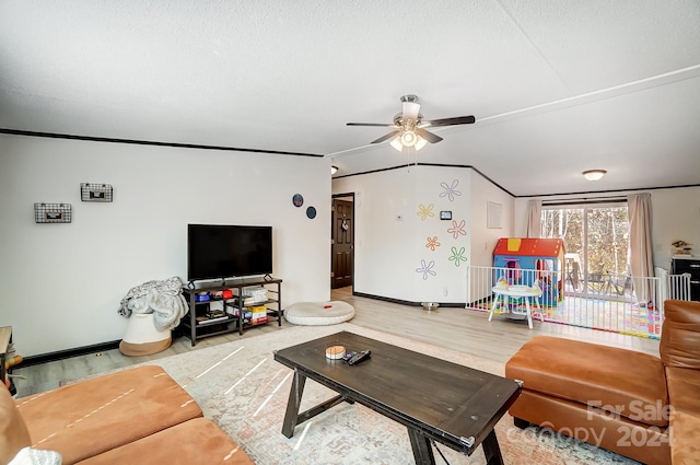 living room with ceiling fan, lofted ceiling, a textured ceiling, hardwood / wood-style flooring, and ornamental molding