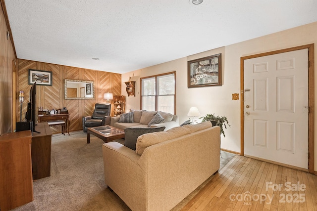 living room with a textured ceiling and wooden walls