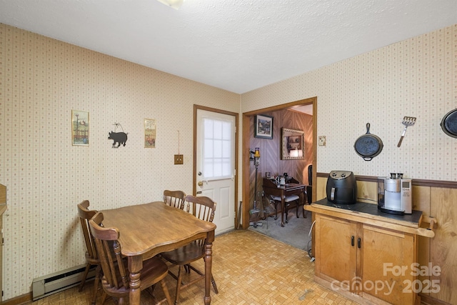 dining space with a textured ceiling and baseboard heating