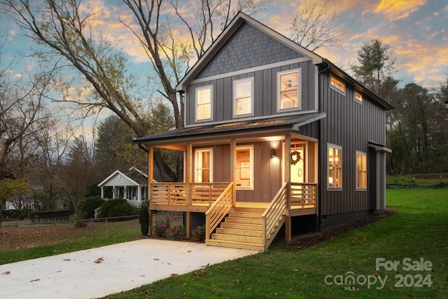 view of front of house with a porch and a yard